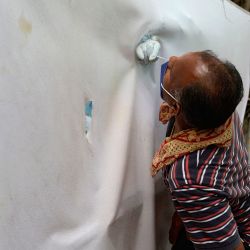 Un trabajador de la salud de detrás de la cortina recoge una muestra de un residente para realizar la prueba del coronavirus Covid-19 en un centro de salud primario del gobierno en Hyderabad. | Foto:NOAH SEELAM / AFP