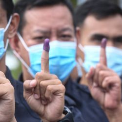 Malasia, Kota Kinabalu: los agentes de policía muestran sus dedos manchados de tinta después de emitir sus votos durante las elecciones estatales de Sabah de 2020. | Foto:Iskandar / BERNAMA / DPA