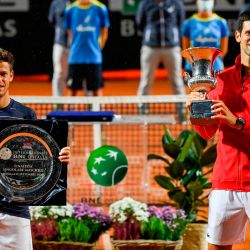 El argentino Diego Schwartzman Y el serbio Novak Djokovic posan con su respectivo trofeo después de que Djokovic ganara el partido final del Abierto de Italia masculino en el Foro Itálico en Roma, Italia. | Foto:Riccardo Antimiani / POOL / AFP