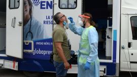 Un periodista de televisión es probado para COVID-19 en un laboratorio de pruebas móvil fuera del estadio Sánchez Pizjuan en Sevilla, como requisito para asistir al partido de fútbol de la final de la Supercopa de la UEFA entre Bayern y Sevilla.