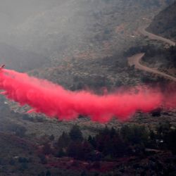 Un avión deja un rastro de retardante de fuego lanzado para combatir el incendio Bobcat en el Bosque Nacional de Ángeles en los Ángeles, California. | Foto:Frederic J. Brown / AFP