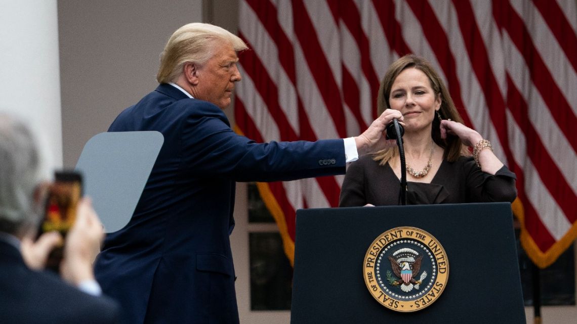 US President Donald Trump adjusts the microphone after he announced Judge Amy Coney Barrett as his nominee to the Supreme Court, in the Rose Garden at the White House, Saturday, September 26, 2020, in Washington.