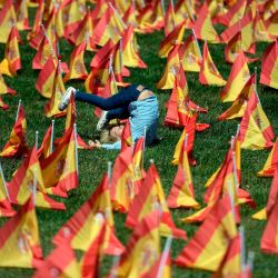 Un niño juega entre miles de banderas españolas, que representan a las víctimas españolas del COVID-19, en el parque Roma de Madrid. | Foto:OSCAR DEL POZO / AFP