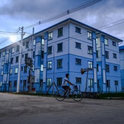 Esta foto muestra a un voluntario en bicicleta en un centro de instalaciones de cuarentena para casos relacionados con el nuevo coronavirus COVID-19 en Yangon. | Foto:Ye Aung Thu / AFP