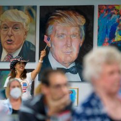 Una mujer ondea una bandera estadounidense mientras los partidarios del presidente Trump observan el debate presidencial en el centro de la Campaña de la Victoria de Trump en Katy, Texas. | Foto:Mark Felix / AFP
