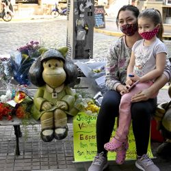 Una mujer y su hija posan junto a estatuas que representan a Mafalda, Susanita y Manolito de los personajes de historietas creados por el dibujante argentino Joaquín Salvador Lavado, conocido como Quino, en Buenos Aires. | Foto:JUAN MABROMATA / AFP