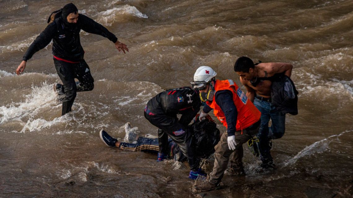 Paramedics and demostrators attend a youth who fell into the Mapocho river from a bridge during a police charge on protesters in Santiago, Chile, Friday September 2, 2020. The incident unleashed a wave of criticism against police for the repression during demonstrations and the government repudiated the acts of violence condemning "categorically any action that violates human rights". The young man is in a hospital in serious but stable condition, according to the latest medical reports. 