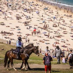 La policía a caballo patrulla mientras la gente visita la playa de Bondi en Sydney. | Foto:DAVID GRAY / AFP