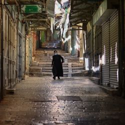 Un sacerdote pasa por tiendas cerradas en la ciudad vieja de Jerusalén en medio de la segunda ola de bloqueo del coronavirus en Israel. | Foto:Emmanuel Dunand / AFP