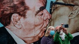 Una pareja se toma una selfie frente al mural