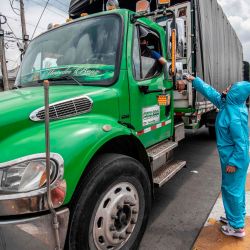 Un trabajador revisa la temperatura corporal de un camionero en medio de la pandemia del nuevo coronavirus COVID-19, en la entrada del mercado general de distribución de alimentos Corabastos, al sur de Bogotá. | Foto:Juan Barreto / AFP