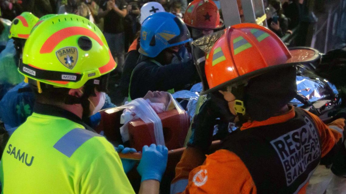 Rescuers carry an injured demonstrator who fell -apparently by accident- to the Mapocho River during a protest against Chilean President Sebastián Piñera's government in Santiago, on October 2, 2020. 
