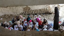Los alumnos yemeníes asisten a clase el primer día del nuevo año académico en un aula improvisada en su recinto escolar, que sufrió graves daños hace dos años en un ataque aéreo, en la tercera ciudad del país, Taez.