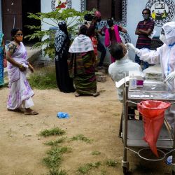 Un trabajador de salud recolecta una muestra de hisopo de un hombre para realizar una prueba del coronavirus Covid-19 en un centro de salud comunitario en las afueras de Hyderabad. | Foto:Noah Seelam / AFP