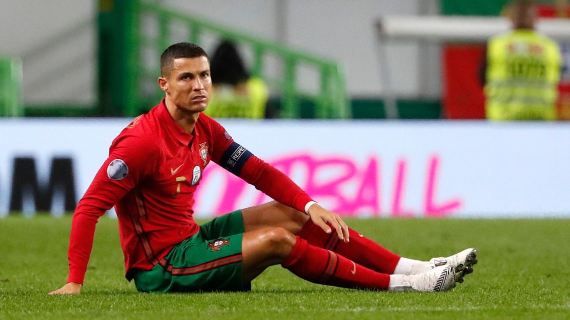 Cristiano Ronaldo, right, sits on the pitch during the international friendly football match between Portugal and Spain at the Jose Alvalade stadium in Lisbon. 