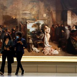 Una pareja pasa junto al óleo sobre lienzo de Gustave Courbet  | Foto:Ludovic Marin / AFP