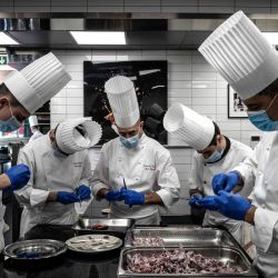 Chefs y cocineros preparan ancas de rana en el restaurante de Paul Bocuse  | Foto:Jeff Pachoud / AFP