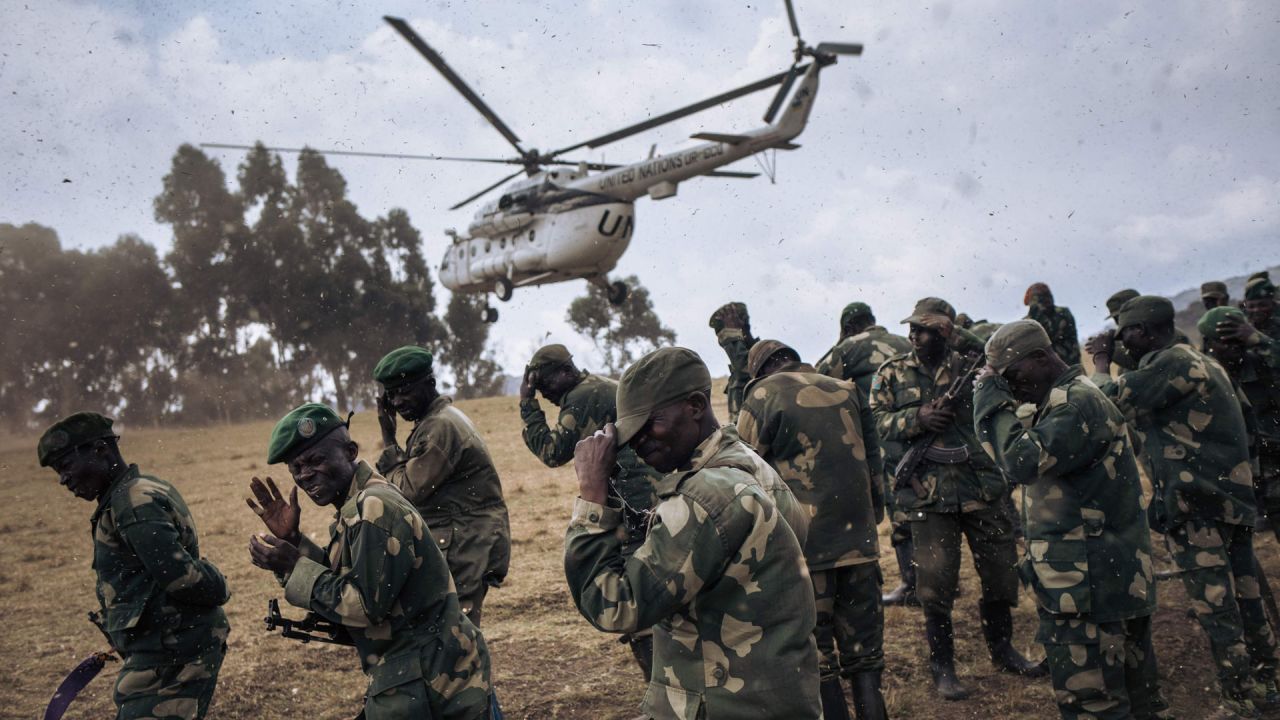 Los soldados del ejército congoleño protegen sus rostros de las proyecciones cuando un helicóptero de la Misión de Estabilización de la Organización de las Naciones Unidas en la República Democrática del Congo aterriza en Bijombo, provincia de Kivu del Sur, en el este de la República Democrática del Congo. | Foto:Alexis Huguet / AFP