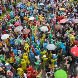 Los manifestantes a favor de la democracia usan ponchos y paraguas para protegerse de la lluvia en Wongwian Yai en Bangkok, mientras continúan desafiando un decreto de emergencia que prohíbe las reuniones. | Foto:Mladen Antonov / AFP