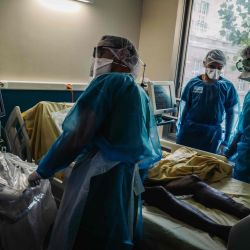 El personal médico transporta a un paciente infectado con Covid-19 en la unidad de cuidados intensivos del Hospital Lariboisiere de la AP-HP (Assistance Publique - Hopitaux de Paris) en París. | Foto:LUCAS BARIOULET / AFP