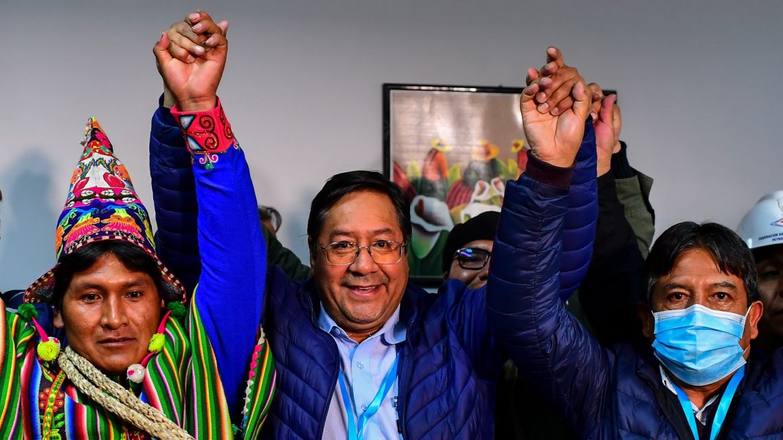 Bolivia's leftist presidential candidate Luis Arce (centre), of the Movement for Socialism party, celebrates with running mate David Choquehuanca (right) early on October 19, 2020, in La Paz, Bolivia. 