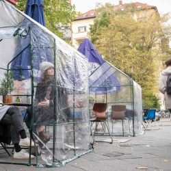 Los invitados se sientan en un pequeño invernadero como medida de protección contra el coronavirus (COVID-19) en una cafetería en Berlín. | Foto:Stefanie Loos / AFP