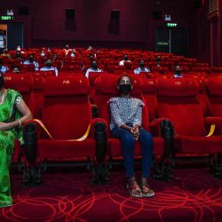 Las personas invitadas a una proyección especial ven la película de Bollywood 'Tanhaji' en un cine en Nueva Delhi. Algunos estados aún mantienen los cines cerrados en medio de la pandemia del coronavirus Covid-19. | Foto:Prakash Singh / AFP
