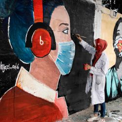 Artistas palestinos pintan murales de colegialas vestidas con máscaras en la ciudad de Gaza, en medio de la nueva crisis pandémica del coronavirus. | Foto:Mohammed Abed / AFP