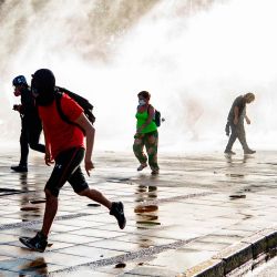 Los manifestantes huyen de un spray de la policía antidisturbios durante una protesta contra el gobierno del presidente chileno Sebastián Piñera en Santiago, antes del referéndum. | Foto:Martin Bernetti / AFP