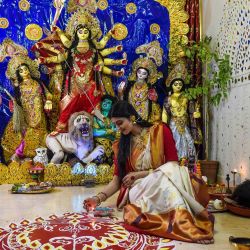 Esta foto muestra al maquillador y modelo Thakkar Virali, posando frente a un ídolo de arcilla de la diosa hindú Durga de diez manos durante las celebraciones del festival 'Durga Puja' en Ahmedabad. | Foto:SAM PANTHAKY / AFP