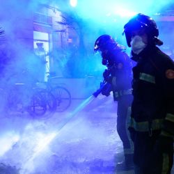 Los bomberos apagaron un incendio tras una manifestación contra el toque de queda y la privación de derechos, en Barcelona. | Foto:Josep Lago / AFP