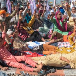 Los agricultores con sus hijos gritan consignas contra el primer ministro de la India, Narendra Modi, durante una protesta que bloquea las vías del tren contra la reciente aprobación de proyectos de ley de reforma agrícola en el Parlamento, en una estación de tren en la aldea de Jandiala Guru, a unos 20 km de Amritsar. | Foto:Narinder Nanu / AFP