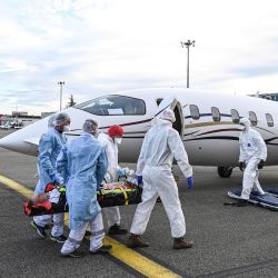 El personal médico lleva a un paciente en una camilla a un vuelo médico en espera en el aeropuerto Bron cerca de Lyon, sureste de Francia, para ser evacuado a otro hospital, en medio del brote del Covid-19 causado por el nuevo Coronavirus. | Foto:PHILIPPE DESMAZES / AFP
