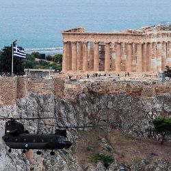 Un helicóptero de la Fuerza Aérea Helénica sobrevuela el Templo del Partenón en la cima de la colina de la Acrópolis en Atenas, durante las celebraciones del Día Nacional  | Foto:Angelos Tzortzinis / AFP