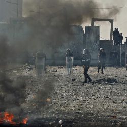 Policías antidisturbios iraquíes avanzan en medio de enfrentamientos con manifestantes antigubernamentales en el puente de Al-Jumhuriyah sobre el río Tigris que conduce a la Zona Verde altamente fortificada, en la capital Bagdad. | Foto:AHMAD AL-RUBAYE / AFP