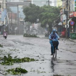 Un hombre viaja por una carretera desierta en medio de fuertes vientos en la provincia de Quang Ngai, en el centro de Vietnam, cuando el tifón Molave toca tierra. | Foto:Manan Vatsyayana / AFP