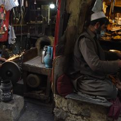 Los herreros trabajan en sus talleres en un mercado en Kabul. | Foto:WAKIL KOHSAR / AFP
