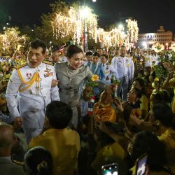 El rey Maha Vajiralongkorn y la reina Suthida de Tailandia saludan a sus seguidores fuera del Gran Palacio de Bangkok después de presidir una ceremonia religiosa en un templo budista dentro del palacio. | Foto:Jack Taylor / AFP
