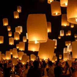 La gente enciende y suelta linternas de papel durante la celebración del festival Loy Krathong en las afueras de Chiang Mai. | Foto:Mladen Antonov / AFP