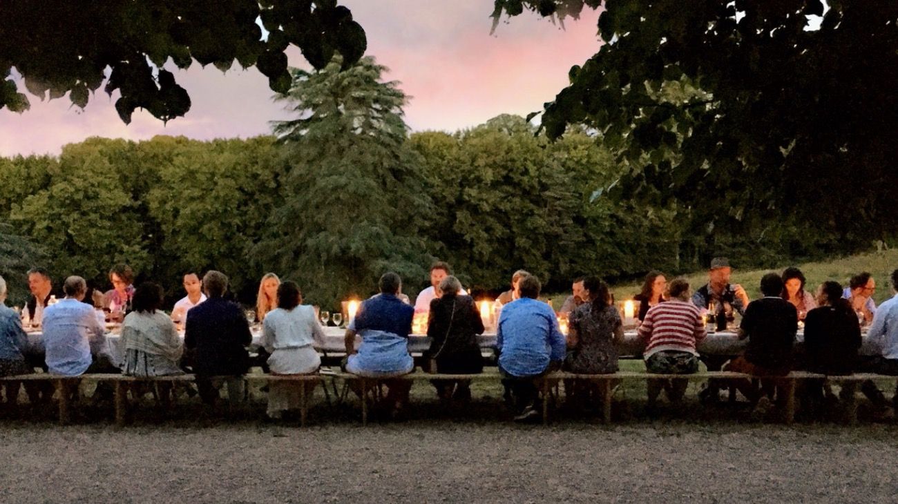 Turistas cenando en uno de los jardines del castillo francés Belebat.