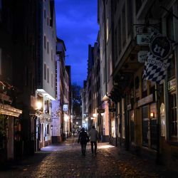 La gente pasa junto a bares y restaurantes cerrados en el casco antiguo de Colonia en medio de la pandemia del nuevo coronavirus (Covid-19). | Foto:Ina Fassbender / AFP