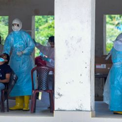 Los trabajadores médicos recogen muestras de hisopos de los residentes para realizar pruebas del coronavirus COVID-19 en Colombo. | Foto:Lakruwan Wanniarachchi / AFP