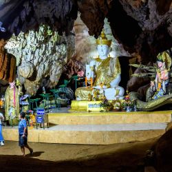 Esta fotografía muestra a los turistas que visitan uno de los santuarios budistas en el complejo de cuevas de Chiang Dao, que se extiende por más de 10 km y contiene santuarios, estatuas e imágenes de Buda, ubicado a unos 70 km al norte de Chiang Mai. | Foto:Mladen Antonov / AFP