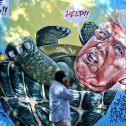 Un hombre pasa junto a un mural del artista australiano Scott Marsh que representa al presidente de los Estados Unidos, Donald Trump, pintado en una pared en Sydney. | Foto:Saeed Khan / AFP