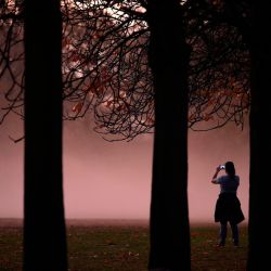 Una persona toma una fotografía de la niebla de la mañana al amanecer en Greenwich Park en el sur de Londres. | Foto:DANIEL LEAL-OLIVAS / AFP