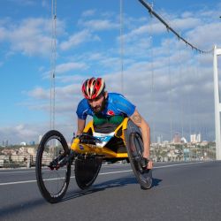 Un competidor discapacitado en silla de ruedas cruza el Puente de los Mártires del 15 de julio, conocido como Puente del Bósforo, mientras compiten en la 42a Maratón anual de Estambul, en Estambul. | Foto:Yasin Akgul / AFP