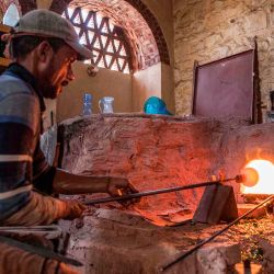 Un soplador de vidrio esculpe un recipiente en un taller cerca del complejo de la mezquita del sultán Qaitbay del siglo XV en el área del  | Foto:Khaled Desouki / AFP