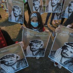Territorios Palestinos, Ciudad de Gaza: los palestinos sostienen pancartas con un retrato del difunto líder político palestino y fundador del movimiento Fatah, Yasser Arafat, dentro de su casa en la ciudad de Gaza durante una ceremonia para conmemorar el 16 aniversario de su muerte. | Foto:Mohammed Talatene / DPA