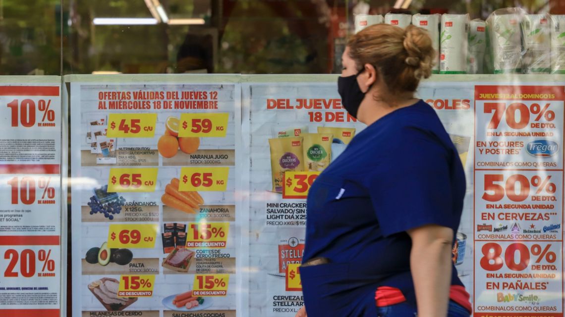 A woman walks past a supermarket in Buenos Aires.
