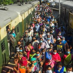 Los viajeros llegan a una estación de trenes suburbanos después de que el servicio de trenes se reanudara tras su cierre debido a la pandemia del coronavirus Covid-19 en Calcuta. | Foto:Dibyangshu Sarkar / AFP